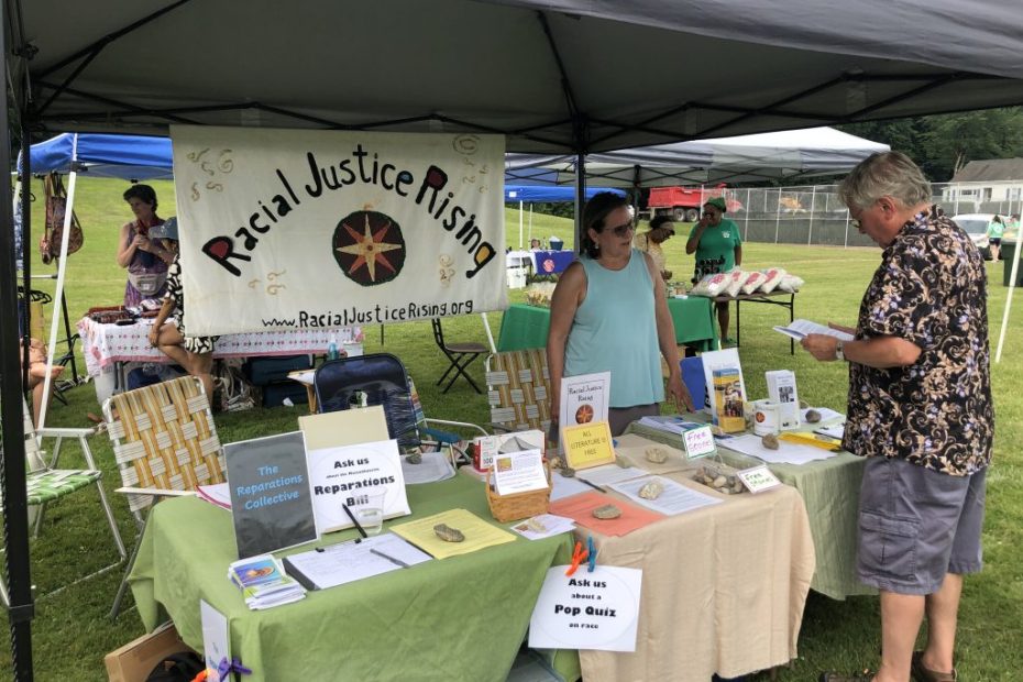 People visiting Racial Justice Rising table at Juneteenth event